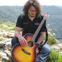 Joe mit Gitarre sitzend in der Landschaft 1