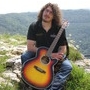 Joe mit Gitarre sitzend in der Landschaft 3